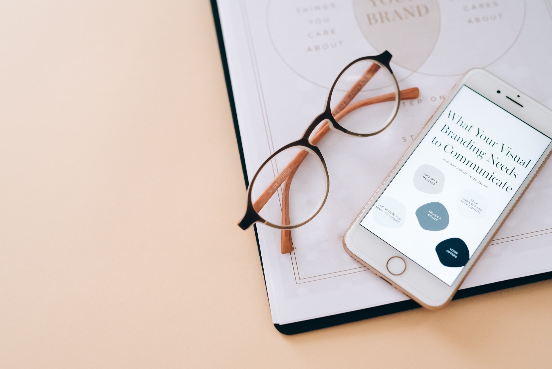 IPhone and a pair of glasses on top of notes